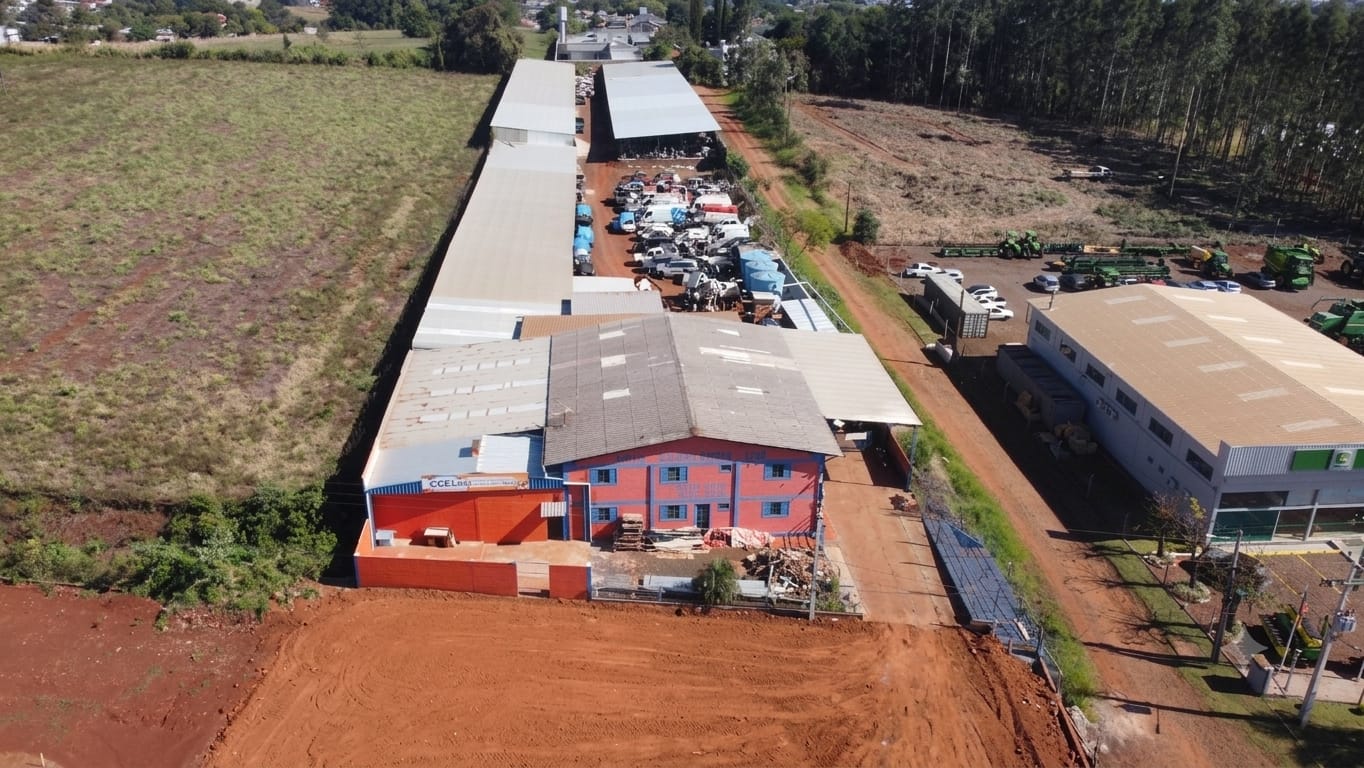 Vista aérea da sede da Auto Demolidora Giruá: galpões de desmontagem e pátio com veículos enfileirados.